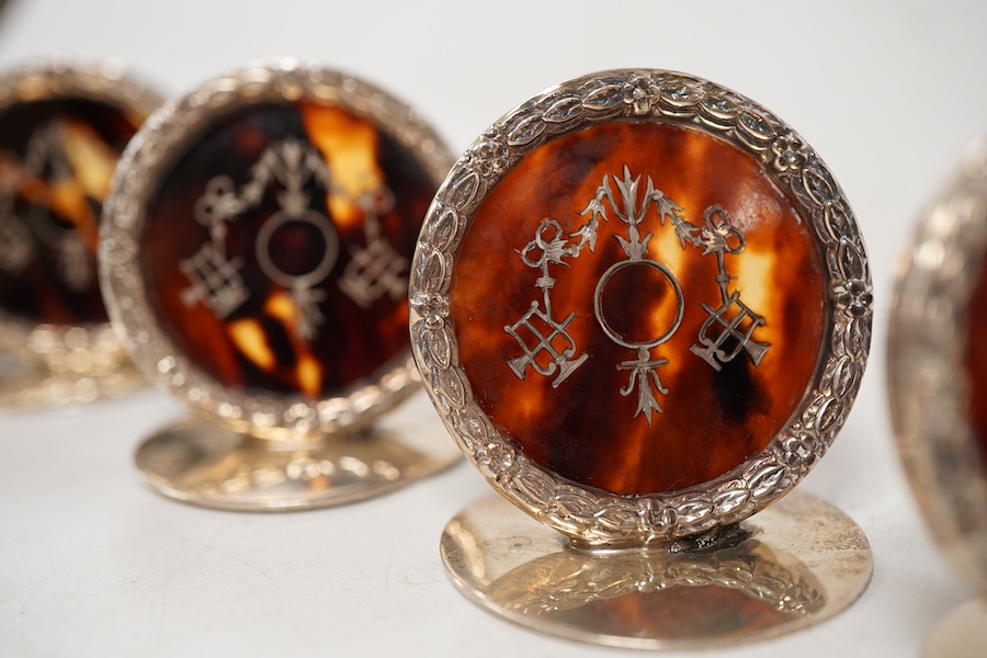 A set of four George V silver and tortoiseshell pique circular menu holders, by William Comyns, Birmingham, 1912/13, height 40mm.